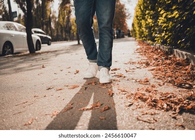 Cropped photo of man in trendy sneakers walking on road pavement sidewalk urban city street style - Powered by Shutterstock