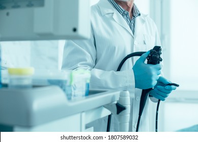 Cropped Photo Of A Man In White Coat And Rubber Gloves Standing With A Modern Endoscope