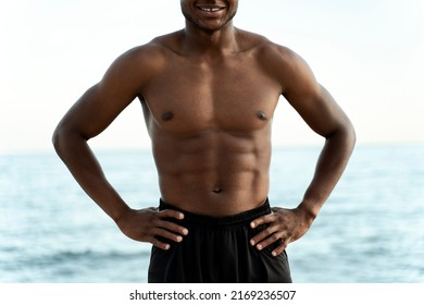 Cropped photo of multiracial man posing with naked torso with summer sea with blue water at the background. Stock photo 