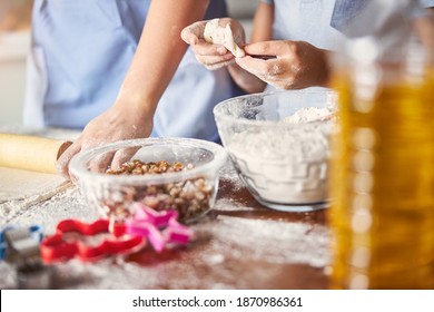 Cropped Photo People Making Dough Near Glass Bowls With Raisins And Flour Sitting On A Messy Kitchen Table