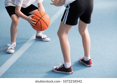 Cropped Photo Of Pupils Playing Basketball In The Gym