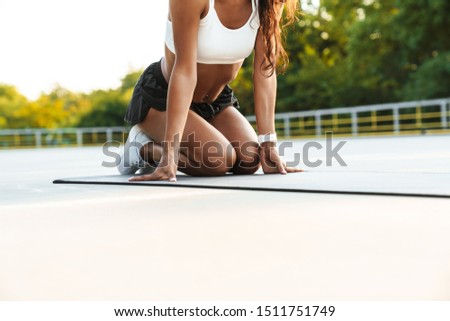 Similar – Young black woman doing stretching after running outdoors