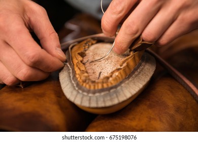 Cropped photo of shoemaker sitting in workshop making shoes - Shutterstock ID 675198076