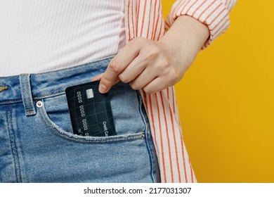 Cropped photo shot close up woman she wears striped shirt white t-shirt hold put into pocket mock up of credit bank card isolated on plain yellow background studio portrait. People lifestyle concept - Shutterstock ID 2177031307