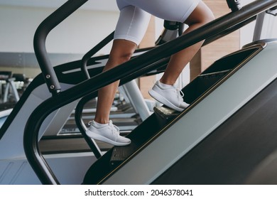 Cropped up photo shot young strong skinny sporty athletic sportswoman woman in white sportswear warm up train run on a treadmill climber stairs machine in gym indoor Workout sport motivation concept