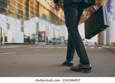 Cropped up photo shot young traveler businessman man wearing black dinner suit walk go outside at international airport terminal with attache case People air flight business trip lifestyle concept.