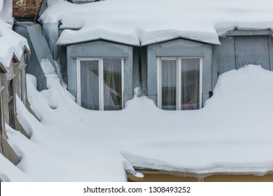 Cropped Photo Of Snow-covered Windows In The Attic Apartment, Roof Leak, Roof Cover Damage, High Precipitation, Danger Of Falling Snow On A Person, Roof Is Covered With Snow, Winter Concept.