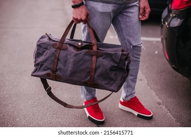 Cropped photo of a well-dressed man with a duffel bag