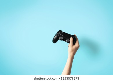 Cropped photo of woman hands holding black analog joystick isolated against pastel light blue background - Powered by Shutterstock