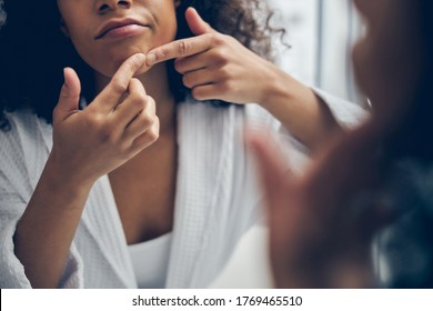 Cropped Photo Of A Woman Removing A Blackhead On Her Face In Front Of The Mirror