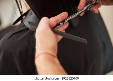 Cropped photo of a young Caucasian female customer getting a professional haircut at a salon