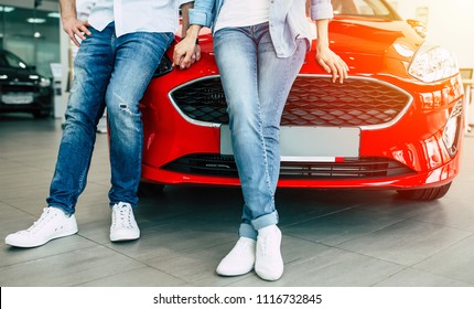 Cropped Photo Of Young Lovely Couple In Casual Wear Buying First New Family Car Together In Dealership. 