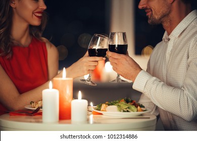 Cropped Photo Of Young Lovers Having Romantic Dinner And Drinking Red Wine At Home