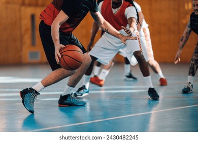 Cropped picture of professional multicultural basketball players practicing basketball on court. Interracial experienced sportsmen are playing basketball on court, dribbling and stealing a ball. - Powered by Shutterstock