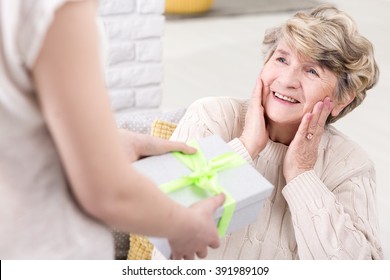 Cropped Picture Of A Young Woman Giving A Present To Her Suprised Grandmother