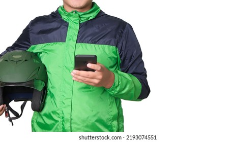 Cropped Portrait Of Asian Online Taxi Driver Wearing Green Jacket Using A Mobile Phone And Holding Helmet. Isolated Image With Empty Space For Text On White Background