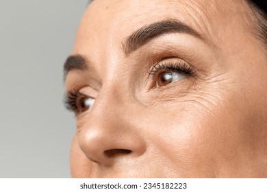 Cropped portrait of beautiful middle-aged woman with healthy, natural condition skin looking away over grey studio background. Fashion, beauty, spa, cosmetology, skin care concept. - Shutterstock ID 2345182223
