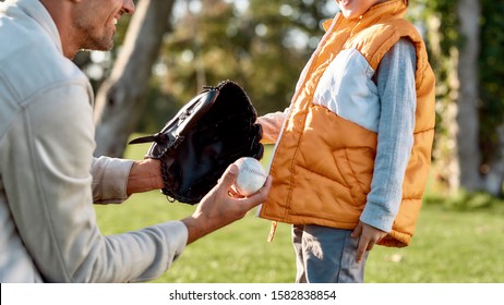 Cropped Portrait Of Man With Kid. Father Holding Baseball Glove While Explaining Rules Of The Game To His Little Boy. Family, Kids And Nature Concept. Horizontal Shot. Side View