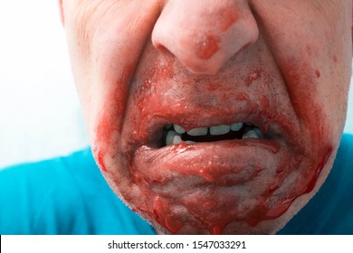 Cropped portrait of a man with open mouth and leaking blood or jam