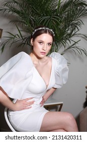 Cropped Portrait In Modern Interior. Bride Posing In Wedding Designer Dress With Puffy Short Sleeves. Delicate Wedding Hair Band Accessory. Fresh Design Elements With Hint Of Nostalgia 80's 90's