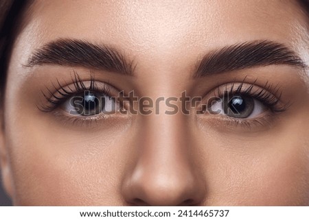 Cropped portrait of young attractive girl with smooth fresh skin. female face, bright eyes, long lushes and brows. Concept of anti-aging skincare cosmetic products that target delicate under-eye area.