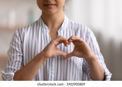 Cropped portrait of young female cardio patient expressing sincere gratitude appreciation to cardiologists volunteers charity givers. Close up of millennial woman posing to camera showing finger heart - Shutterstock ID 1902905809