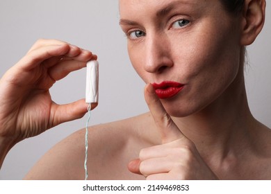 Cropped Portrait Of Young Woman Is Holding Tampon And Showing Shhh Sign.