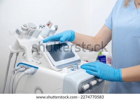 Cropped professional dermatologist setting up and using hydra facial peel machine with hand pieces and cables. Facial beauty treatment in spa clinic. Electrolysis antiaging technology, hygiene  Stock fotó © 