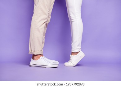 Cropped profile side photo of couple man and woman legs woman tip toes kiss isolated on purple color background
