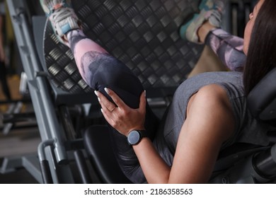 Cropped Rear View Shot Of A Female Athlete Working Out On Leg Press Gym Machine