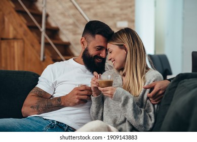 Cropped shot of an affectionate young couple at home drinking coffee - Shutterstock ID 1909143883