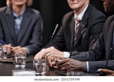 Cropped shot of African American politician at meeting table with microphones giving speech during press conference, copy space