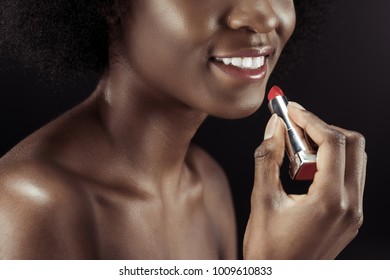 cropped shot of african american woman applying lipstick isolated on black