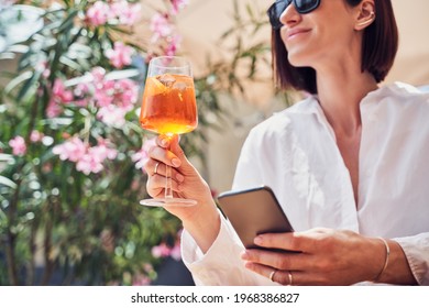 Cropped shot of attractive girl drinking aperol