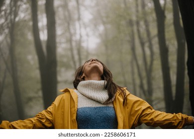 Cropped shot of an attractive young woman breathing and standing with her arms outstretched in nature. - Shutterstock ID 2258606171