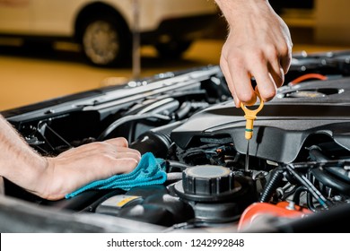 Cropped Shot Of Auto Mechanic With Rag Checking Automobile