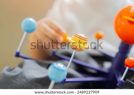 Cropped shot of Boy studying Planets or planetary science with model toy of our solar system. Kids Learning Planets concept.