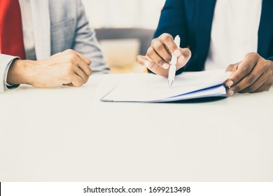 Cropped shot of business people reading contract. Close-up partial view of professional business colleagues working with papers in office. Paperwork concept