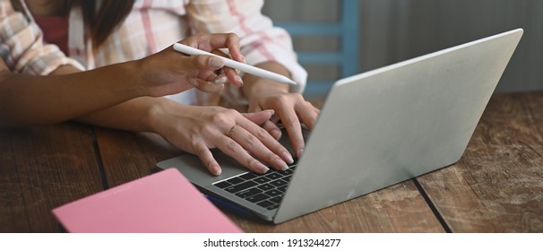 Cropped shot of business people working with laptop computer and discussing over new business project in office. - Shutterstock ID 1913244277