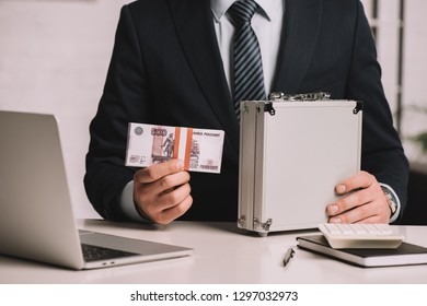 Cropped Shot Of Businessman Holding Suitcase Safe Box And Russian Rubles Banknotes At Workplace