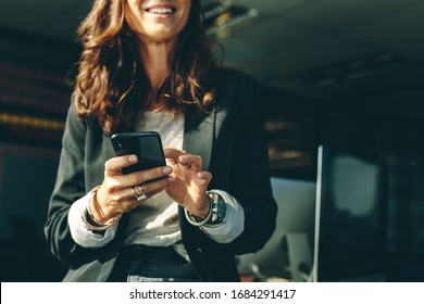 Cropped shot of a businesswoman with a on mobile phone in office. Business executive using a phone in office. - Powered by Shutterstock