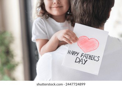 Cropped shot of a cheerful small kid daughter holding greeting card for her father to congratulate him with father`s day, make him surprise and gift. Fatherhood. I love you, dad! - Powered by Shutterstock