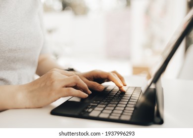 Kopfaufnahmen von selbstbewusster Frau, die auf Laptop arbeitet, während sie im Kreativbüro oder Café sitzt