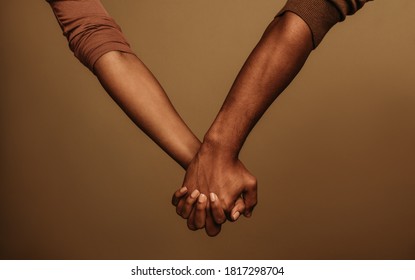 Cropped shot of couple holding hand interlocking fingers. Two people holding hand standing side by side.