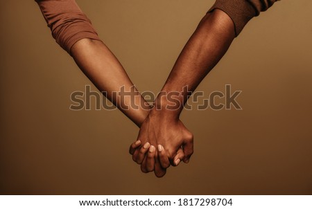 Cropped shot of couple holding hand interlocking fingers. Two people holding hand standing side by side.