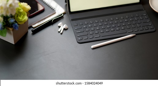 Cropped Shot Of Dark Modern Workplace With Office Supplies On Black Table Background 