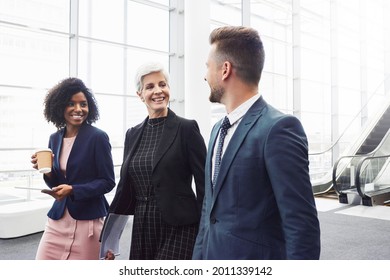 Cropped Shot Of A Diverse Group Of Businesspeople Having A Discussion While Walking Through A Modern Workplace