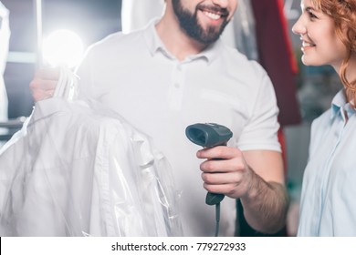 Cropped Shot Of Dry Cleaning Workers Scanning Bag With Clothes