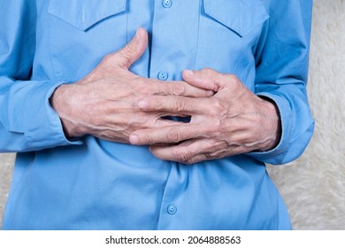 Cropped Shot Of Elderly Man Hands Holding Stomach, Suffering From Stomachache. White Background