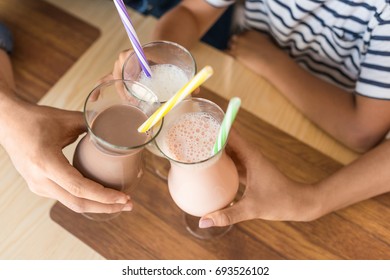 Cropped Shot Of Family Clinking With Glasses Of Milkshakes